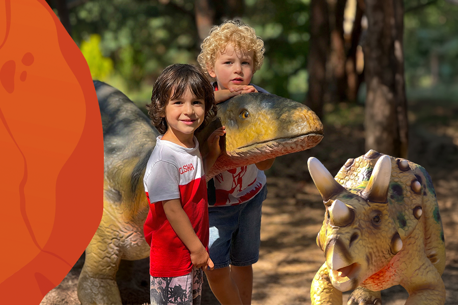 Materiał graficzny promujący wydarzenie „Kupujesz i dinozaurujesz”. Przedstawia dwójkę dzieci w Dolinie Dinozaurów.