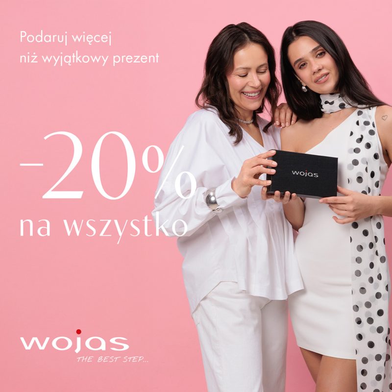 Zdjęcie reklamowe ukazuje radosną kobietę w stylowej, beżowej marynarce i spodniach, otoczoną przez pastelowe kompozycje kwiatowe. Całość dopełnia panel informacyjny po lewej stronie, ogłaszający promocję na produkty marki Wojas z darmową dostawą i zwrotem.