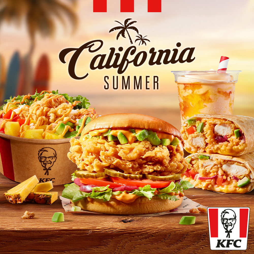 Plakat promocyjny menu California Summer w restauracji KFC w Galerii Młociny. Na pierwszym planie na drewnianym stole leżą apetyczne potrawy: burger z chrupiącym kurczakiem, kostkami awokado i pomidorem, przekrojone burrito z ryżem i kurczakiem, miska Poke Bowl oraz zimny napój z rurką California Fizzy Drink. Wokół leżą kawałki ananasa i awokado. W tle widać plażę, palmy i zachód słońca. Na górze widnieje czarny napis California SUMMER z rysunkiem palmy, a w prawym dolnym rogu czerwono-białe logo KFC.