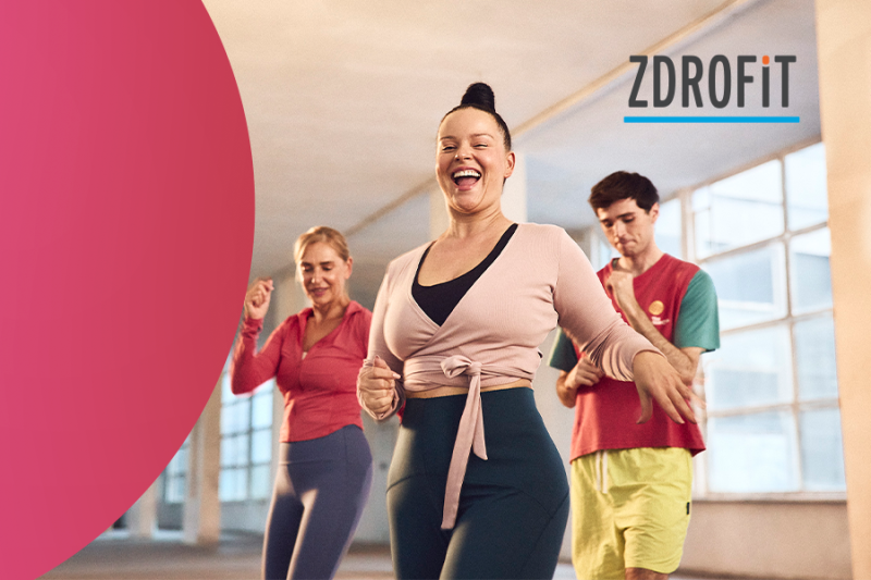 Plakat informacyjny o bezpłatnych zajęciach Zumby na Tarasie Galerii Młociny. Grafika przedstawia roztańczonych uczestników na świeżym powietrzu oraz napisy z datą i czasem wydarzenia: W każdy wtorek sierpnia, godzina 18:00, Taras Galerii Młociny, organizator Zdrofit.