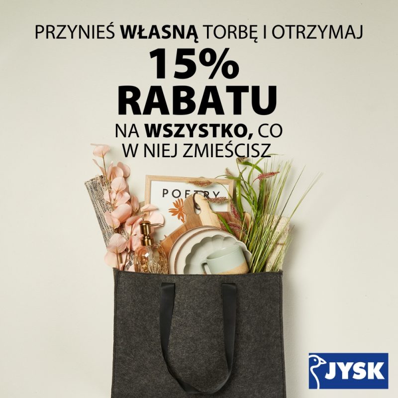 Grafika promocyjna sklepu JYSK informująca o akcji „Przynieś własną torbę i otrzymaj 15% rabatu na wszystko, co w niej zmieścisz”. Na grafice widoczna jest materiałowa torba wypełniona artykułami do domu, takimi jak dekoracje, naczynia i rośliny. W prawym dolnym rogu znajduje się logo JYSK.