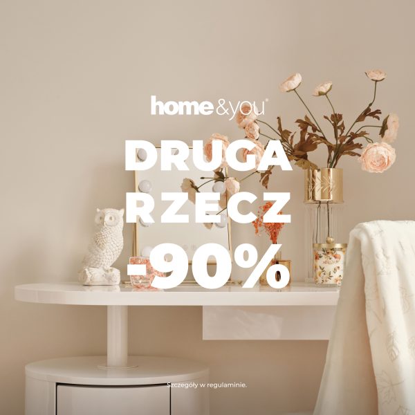 Baner promocyjny marki home&you z hasłem „DRUGA RZECZ -90%”. Na zdjęciu przedstawiono białe toaletki ze stylowymi dodatkami: figurką sowy, wazonem z kwiatami i podświetlanym lusterkiem.