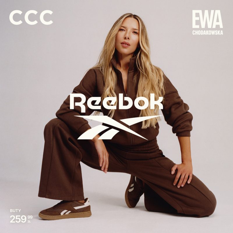 Kwadratowe zdjęcie wizerunkowe kolekcji Reebok x Ewa Chodakowska w sklepie CCC. Na jasnym tle przedstawiono Ewę Chodakowską w pozycji klęczącej, ubraną w brązowy zestaw dresowy oraz brązowe buty sportowe z jasnymi detalami. W prawym i lewym górnym rogu znajdują się białe logotypy CCC oraz EWA CHODAKOWSKA, na środku umieszczono duże białe logo marki Reebok, a w lewym dolnym rogu napis BUTY 259,99 ZŁ.