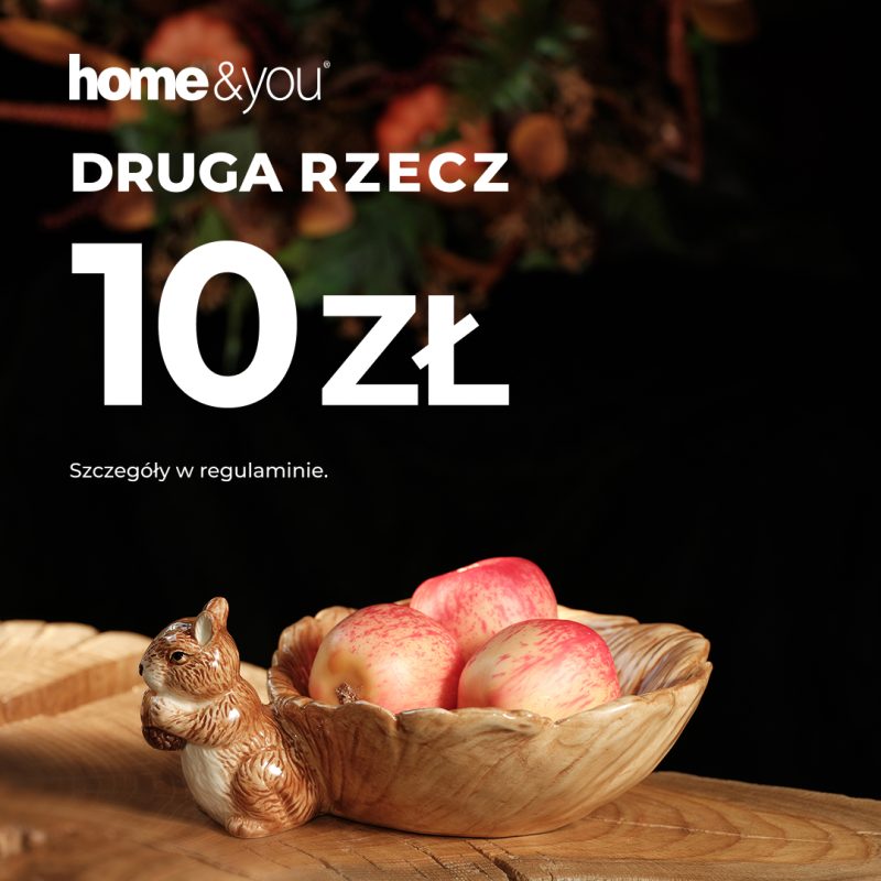 Kwadratowa grafika promocyjna salonu home&you utrzymana w jesiennej tonacji. Na ciemnym tle umieszczono biały logotyp home&you, napis DRUGA RZECZ 10 zł oraz informację Szczegóły w regulaminie. Na drewnie zaprezentowano dekoracyjną ceramikę w kształcie liści z figurkami wiewiórek, z których jedna służy jako miseczka wypełniona czerwonymi jabłkami.
