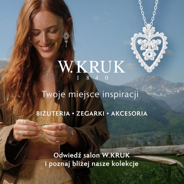 Uśmiechnięta rudowłosa kobieta w górskiej scenerii prezentująca srebrną biżuterię oraz zawieszkę w kształcie serca w kampanii W.KRUK w Galerii Młociny