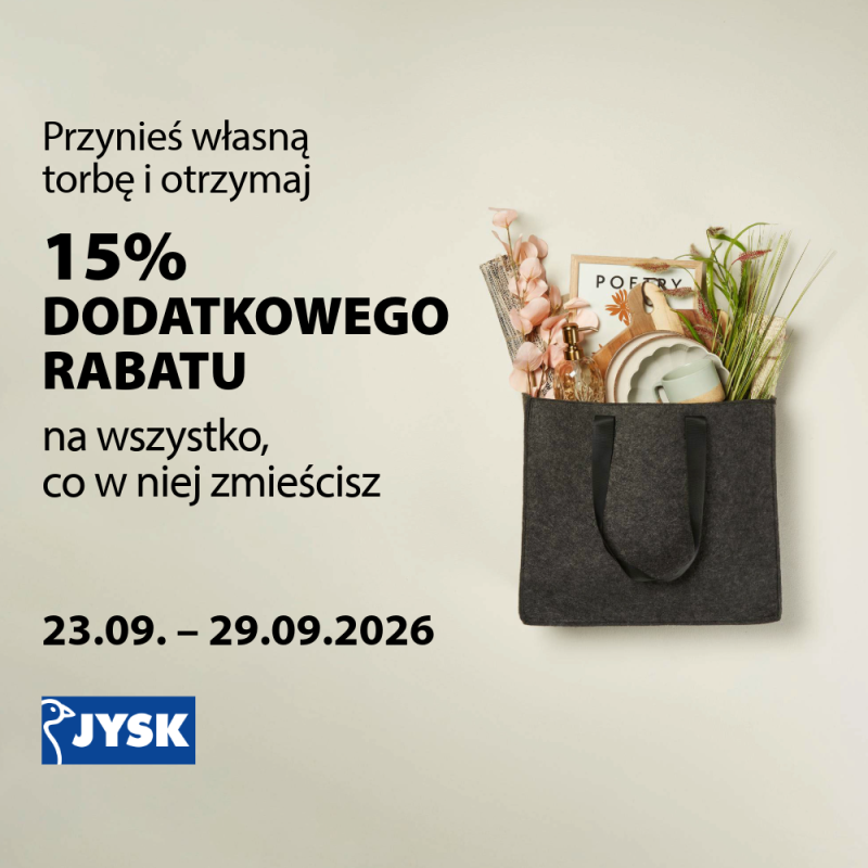 Grafika promocyjna marki Jysk informująca o akcji specjalnej pod hasłem „Przynieś własną torbę i otrzymaj 15% DODATKOWEGO RABATU na wszystko, co w niej zmieścisz”. Promocja obowiązuje w dniach 23.09. – 29.09.2026 r. Po prawej stronie widoczna jest ciemna, materiałowa torba wypełniona artykułami dekoracyjnymi i domowymi. W lewym dolnym rogu znajduje się niebiesko-białe logo marki Jysk.